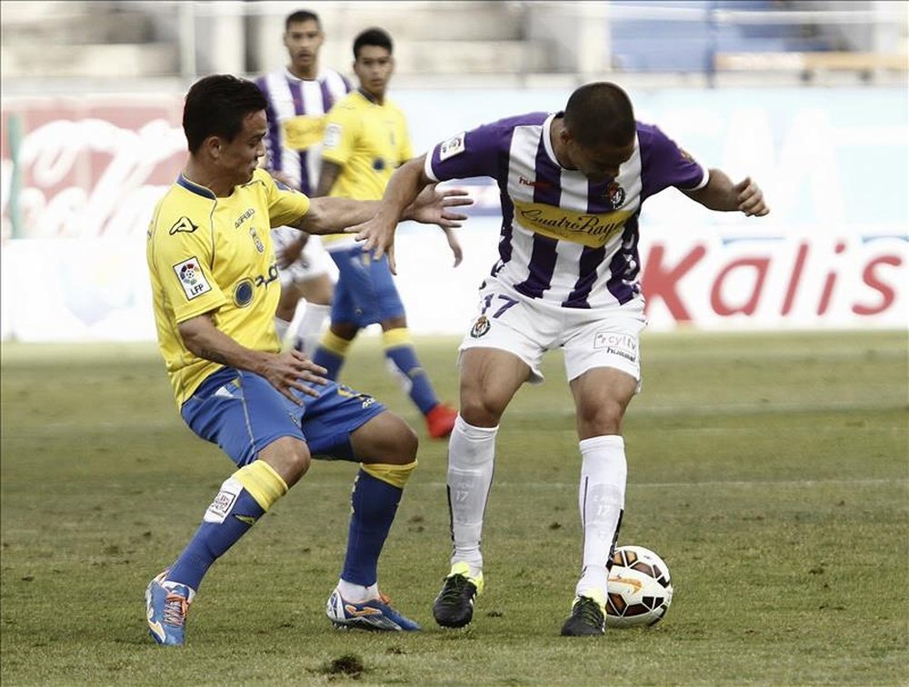 El defensa del Real Valladolid, Carlos González Peña (d), intenta controlar el balón ante el jugador de Las Palmas, durante el partido de vuelta de promoción a primera división, que disputaron ayer en el Estadio de Gran Canaria. EFE