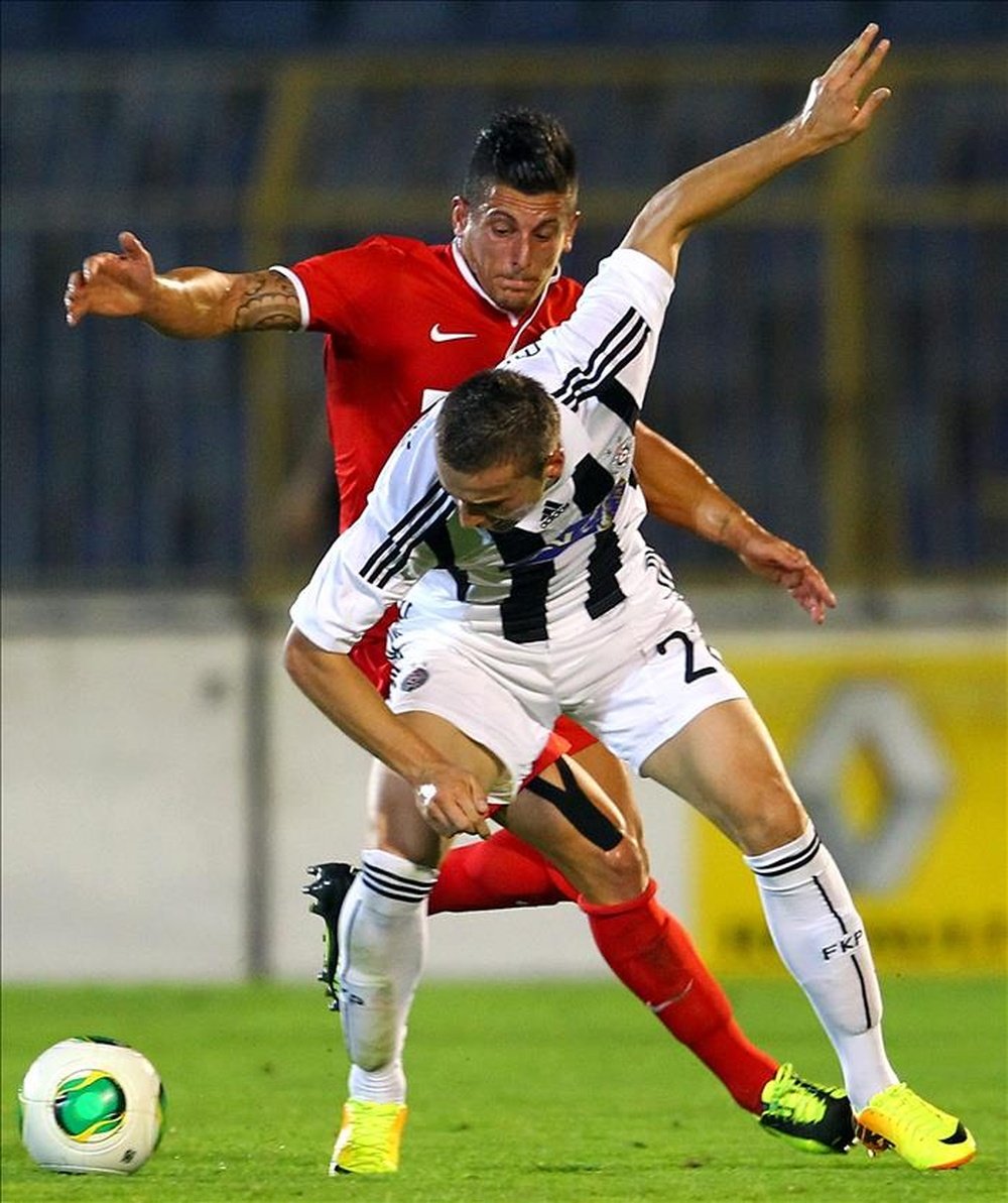 El jugador del FC Thun Dennis Hediger (atrás) disputa el balón con Sasa Markovic (adelante), del Partizan, durante el partido clasificatorio a la Liga Europa de la UEFA en Belgrado (Serbia). EFE/Archivo