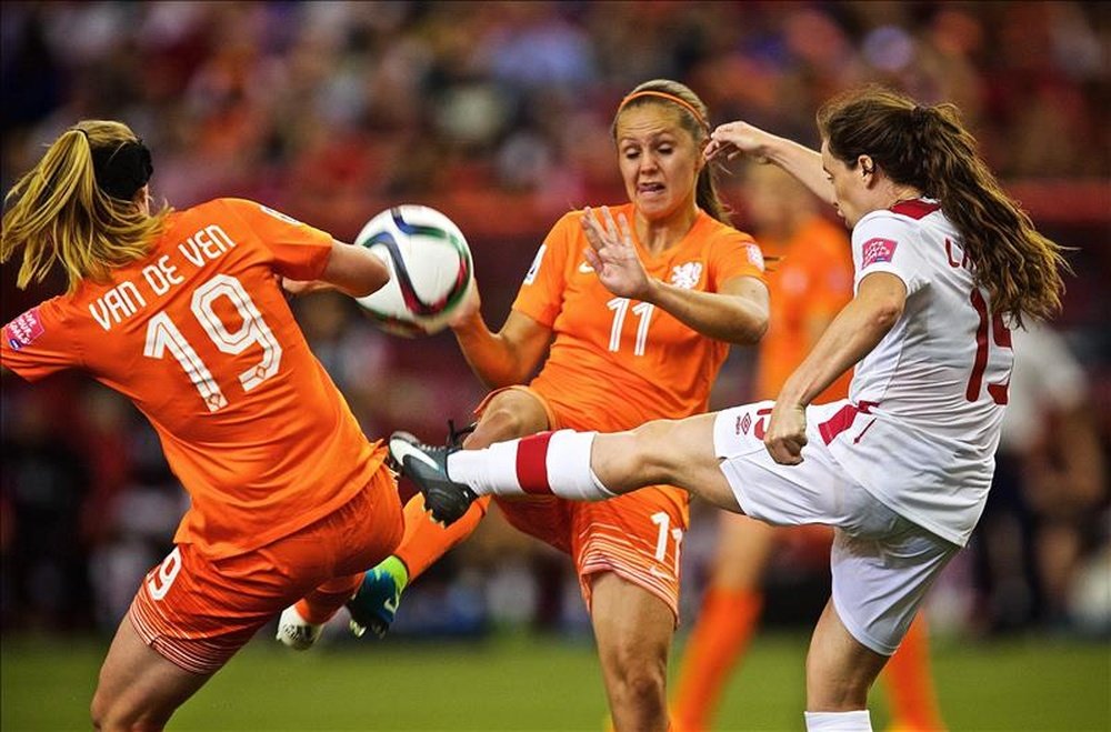 La jugadora de Holanda Kirsten Van De Ven (i) y Lieke Martens disputa el balón con Allysha Chapman (d) Canadá este 15 de junio, durante un partido del grupo A del Mundial de fútbol femenino celebrado en el estadio Olímpico de Montreal (Canadá). EFE