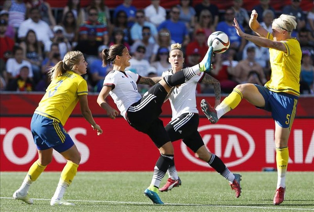 Dzsenifer Marozsan (c) de Alemania intenta controlar el balón ante la marca de Nilla Fischer (d) de Suecia durante el partido por los octavos de final del Mundial de fútbol femenino de la FIFA Canadá 2015 en Ottawa. EFE