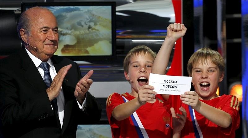 Joseph Blatter (i) aplaude mientras dos niños muestran una papeleta con la ciudad de Moscú. EFE/Archivo