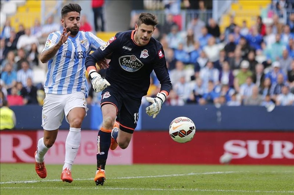 El portero del Deportivo Fabricio Agosto corre hacia el balón en presencia del delantero del Málaga Samuel García Sánchez. EFE/Archivo
