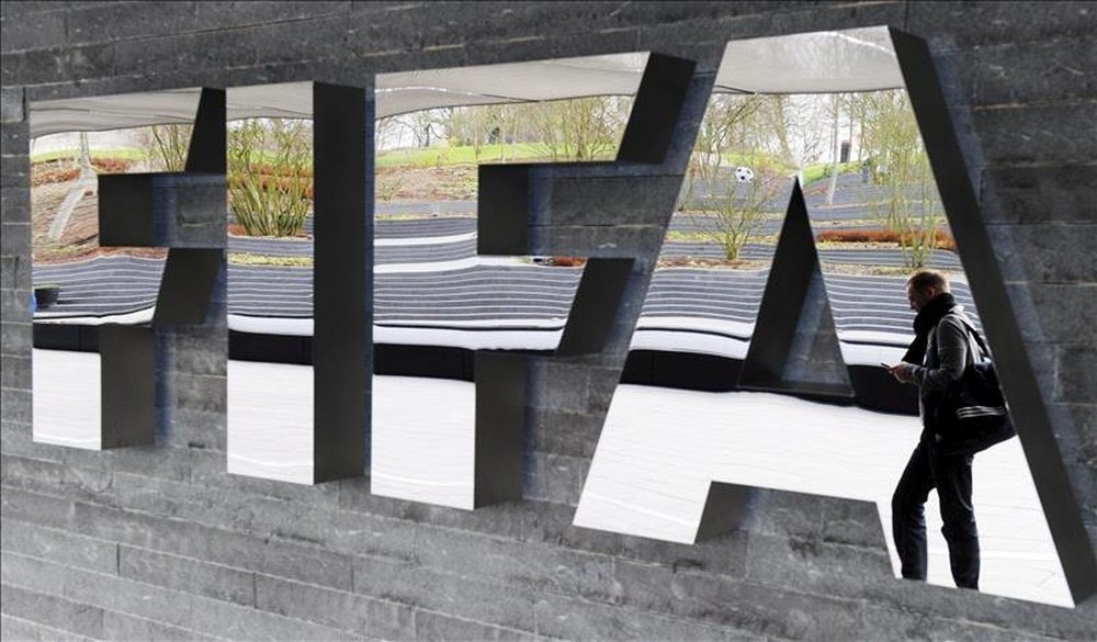 Un hombre pasa junto a un logo de la FIFA en Zurich (Suiza). EFE/Archivo 