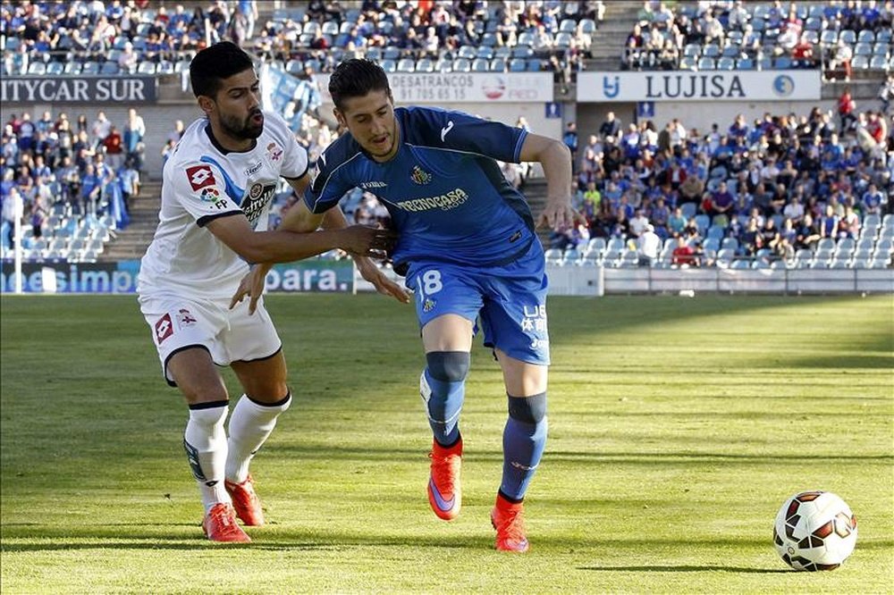 El defensa del Deportivo Juanfran Moreno (i) disputa un balón con el defensa del Getafe Sergio Escudero (d). EFE/Archivo