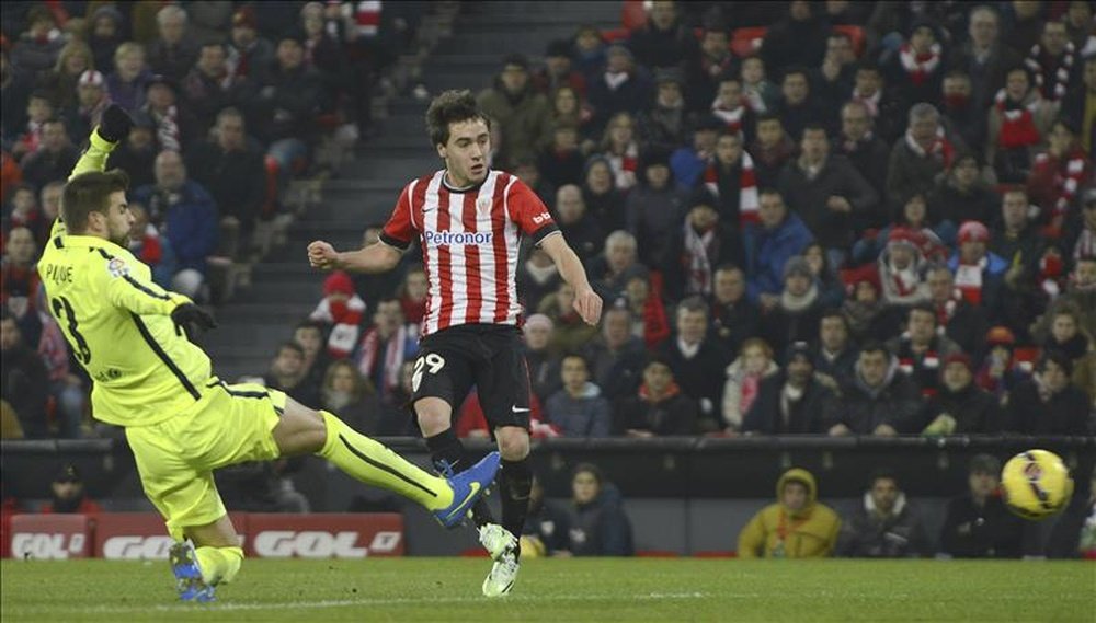 El centrocampista del Athletic de Bilbao, Unai López (d), golpea el balón ante el defensa del F. C. Barcelona, Gerard Piqué. EFE/Archivo