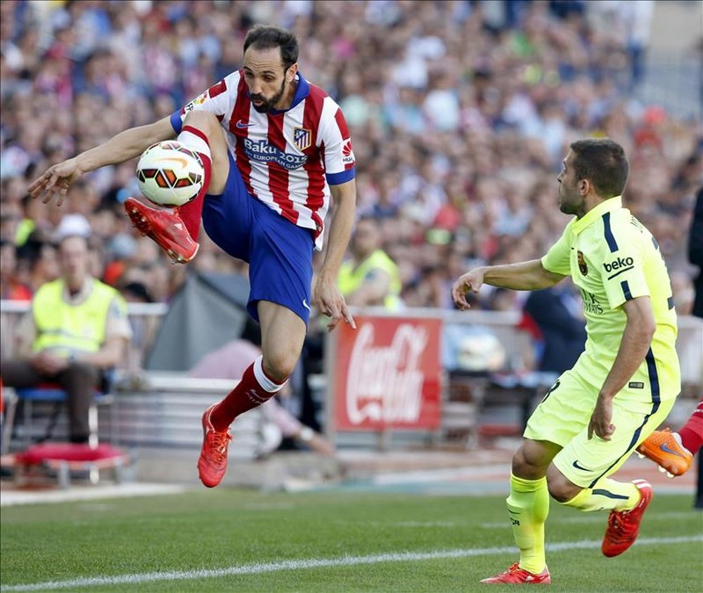 El defensa del Atlético de Madrid, Juanfran Torres (i), controla el balón ante Jordi Alba (d), del Barcelona. EFE/Archivo