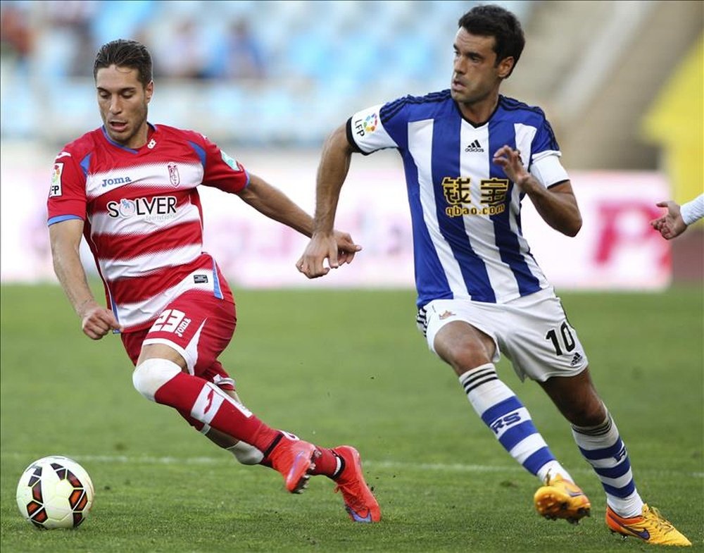 El centrocampista de la Real Sociedad Xabi Prieto (d) disputa un balón con el centrocampista del Granada Rubén Rochina (i). EFE/Archivo