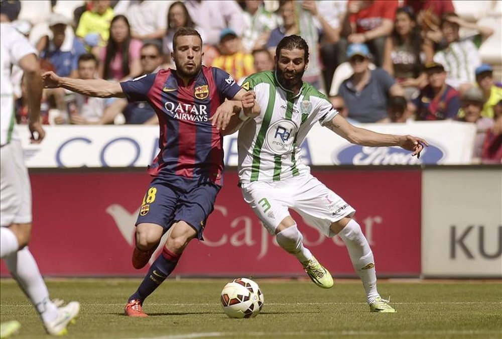El defensa del FC Barcelona Jordi Alba (i) disputa un balón con el defensa Jose Ángel Crespo (d), del Córdoba. EFE/Archivo