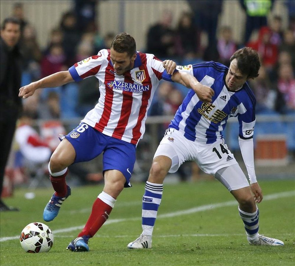 El centrocampista del Atlético de Madrid Koke (i) lucha un balón con el centrocampista de la Real Sociedad Rubén Pardo (d), durante el partido de trigésima jornada de liga de Primera División. EFE/Archivo
