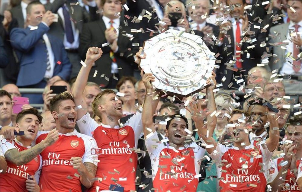 Los jugadores del Arsenal se fotografían con el trofeo que revalida su titulo en la Community Shield tras golear al Chelsea en un encuentro entre ambos equipos de futbol en el estadio Wembley, en Londres, Reino Unido, hoy 2 de agosto de 2015. EFE