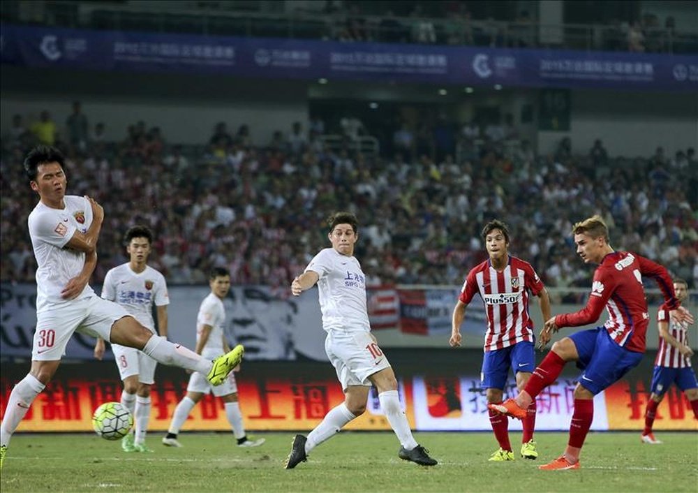 El delantero francés del Atlético de Madrid Antoine Griezmann (d) dispara a puerta durante el partido amistoso que el conjunto rojiblanco disputa hoy contra el Shanghái SIPG, en Shanghái. EFE