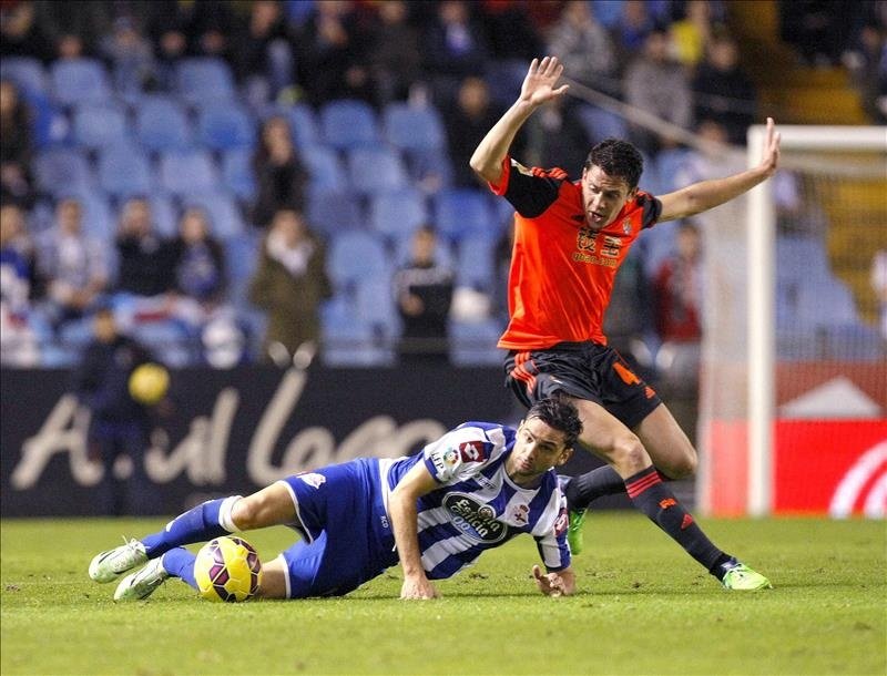 El defensa de la Real Sociedad Gorka Elustondo (d) lucha el balón con el delantero portugués Helder Postiga, del Deportivo de La Coruña, durante el partido de Liga de la duodécima jornada en Primera División, en el estadio de Riazor, en A Coruña. EFE/Archivo