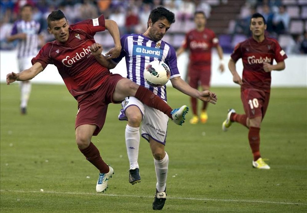 El defensa del Córdoba CF, José Manuel Fernández (i), intenta robarle la pelota al defensa del Real Valladolid, Carlos Peña (c), durante un partido la pasada temporada. EFE/Archivo