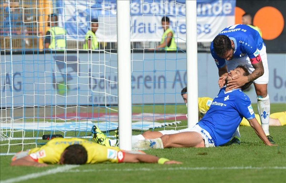 El capitán del Darmstadt captain Aytac Sulu (d) junto a Gyorgy Garics (2-d) reacciona tras un gol durante el partido SV Darmstadt y 1899 Hoffenheim en el Merck-Stadion de Darmstadt, Alemania.  EFE/EPA