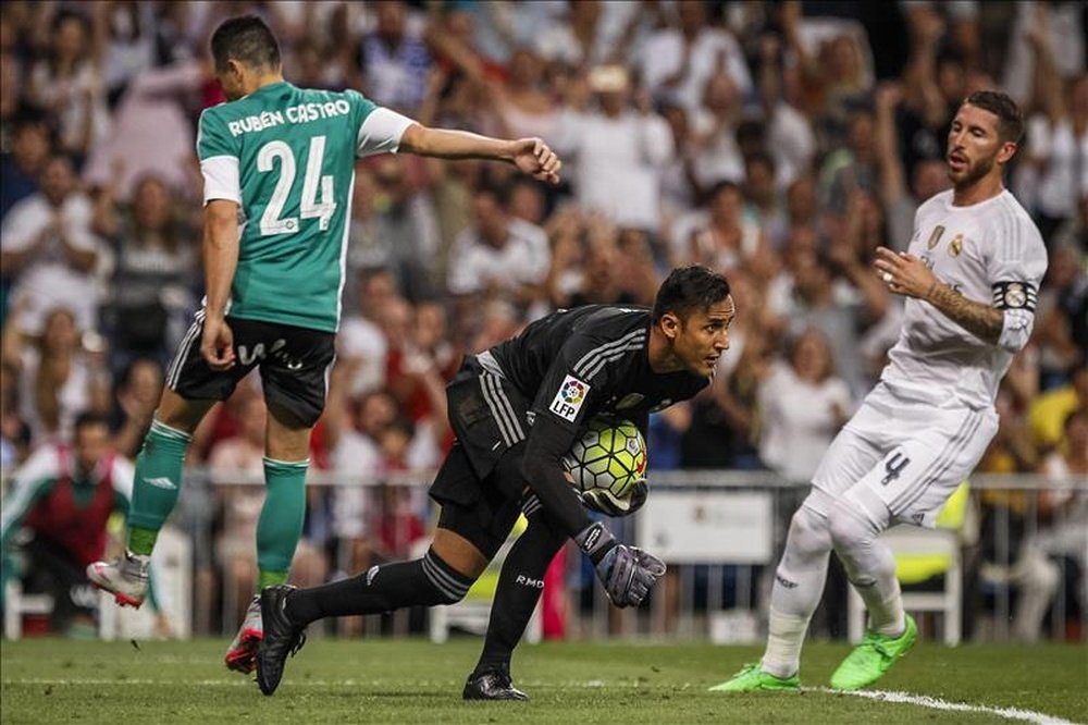 El portero costarricense Keylor Navas (c), del Real Madrid, para el penalti que lanzó Rubén Castro (i), del Betis, durante el partido de la segunda jornada de Liga que Real Madrid y Real Betis jugaron en el estadio Santiago Bernabéu. EFE