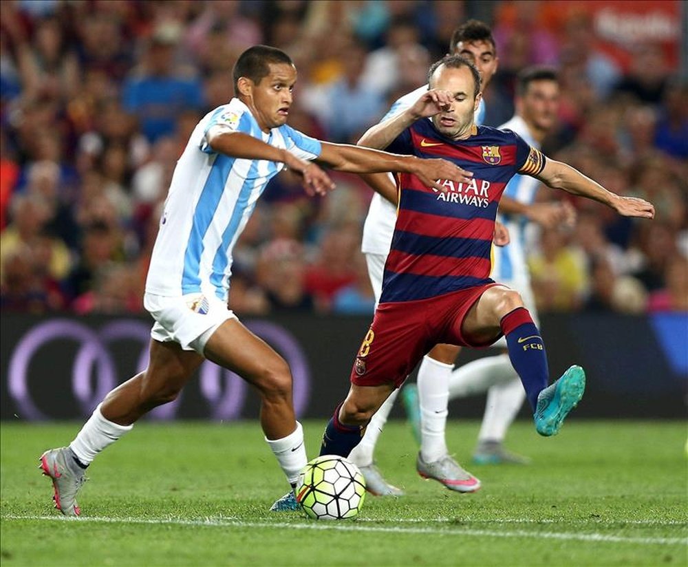 El centrocampista del FC Barcelona Andrés Iniesta (d) lucha por el balón durante el partido de este sábado que FC Barcelona y Málaga CF disputaron en el Camp Nou, en Barcelona. EFE