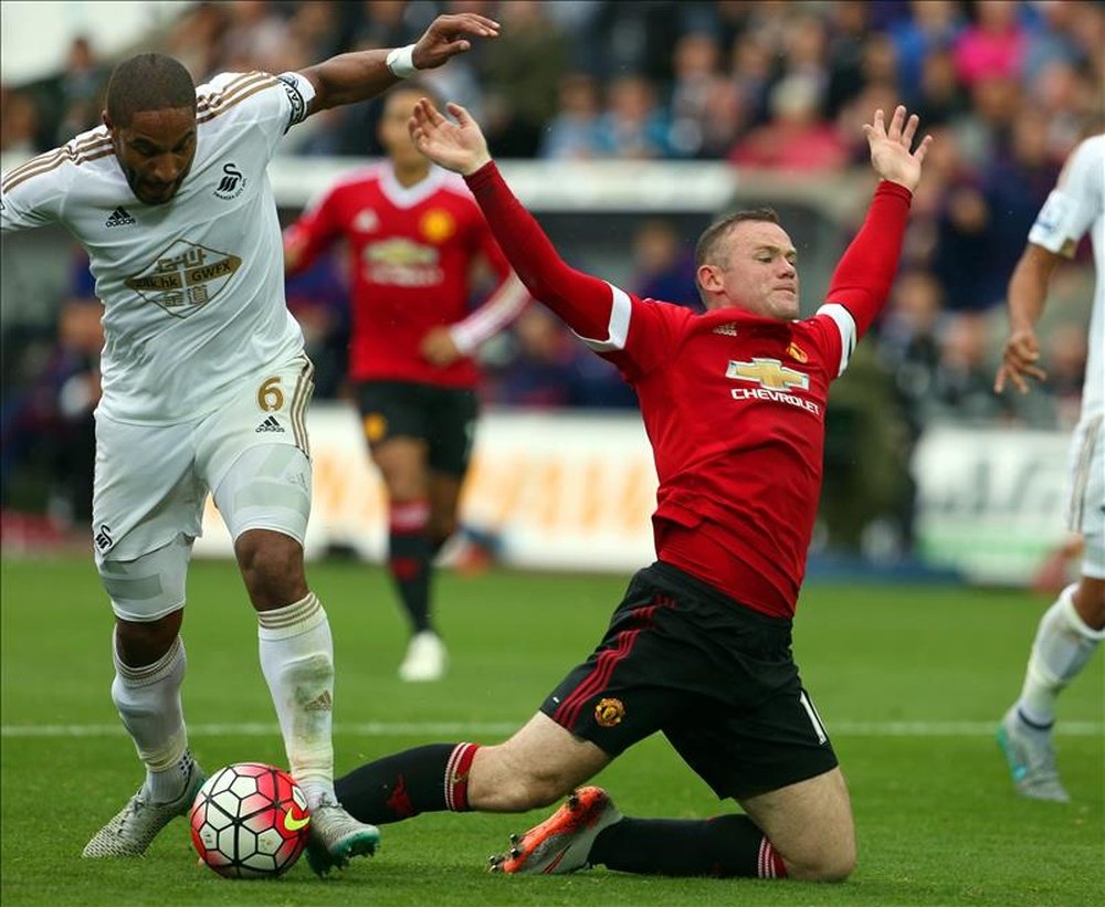 Manchester United striker Wayne Rooney (R) falling in the box against Ashley Williams. EFE