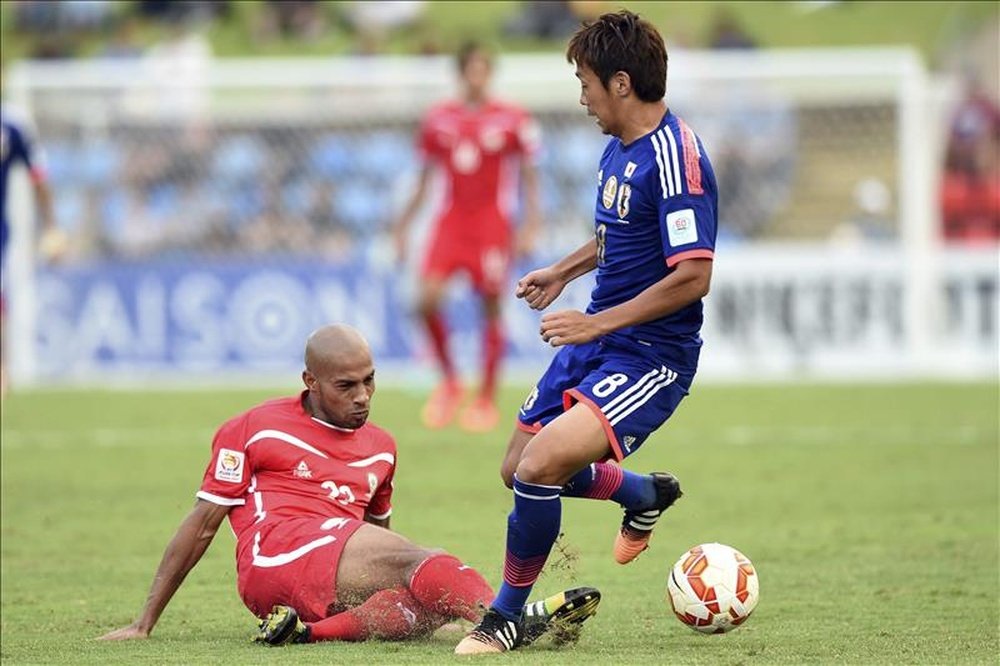 El palestino Murad Said (izda) lucha por el balón con el japonés Hiroshi Kiyotake durante el partido de la Copa Asia contra Palestina en el estadio de Newcastle en Japón. EFE/Archivo