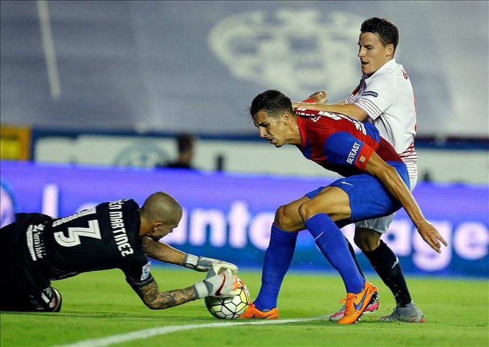 El guardameta del Levante, Rubén (i), captura el balón ante su compañero, Ángel Trujillo (c), y el delantero francés del Sevilla, Kevin Gameiro, durante un partido. EFE/Archivo