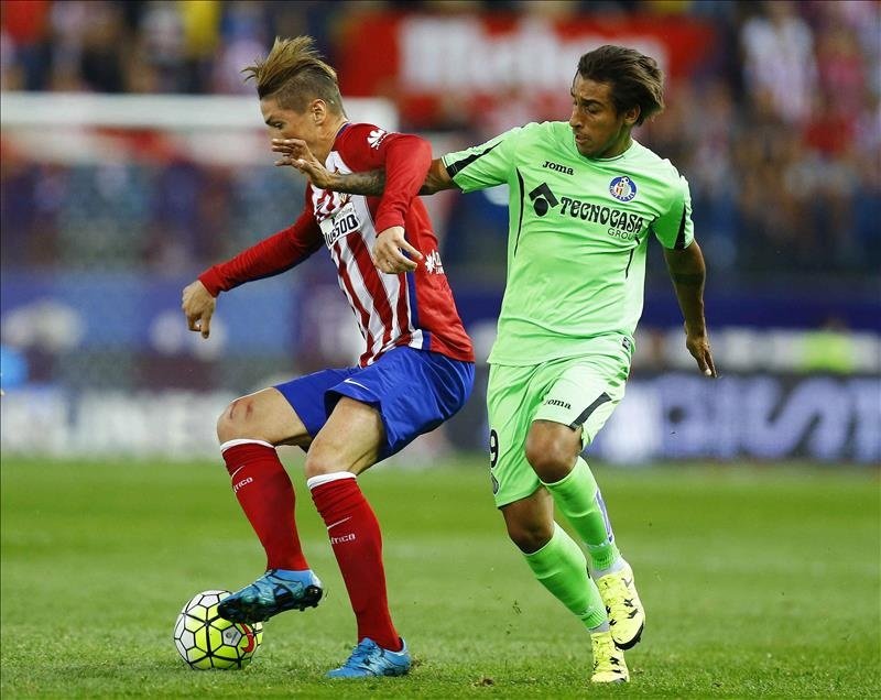 El delantero del Atlético de Madrid Fernando Torres (i) lucha el balón con el uruguayo Damián Suárez, del Getafe CF, durante un partido. EFE/Archivo