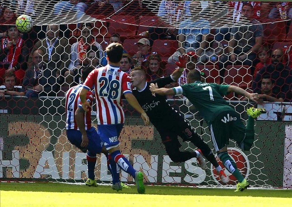 El centrocampista del Real Betis Joaquín Sánchez (d) marca ante el portero del Sporting Alberto García (2d), durante el partido de la sexta jornada de Liga de Primera División disputado hoy en el estadio de El Molinón. EFE