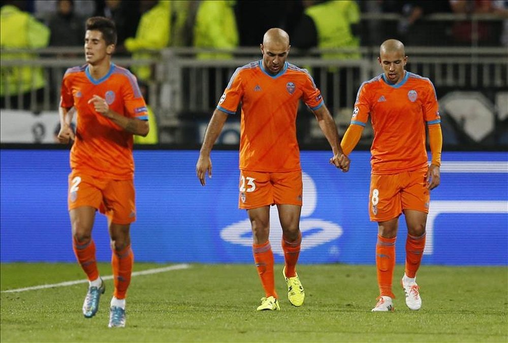 El jugador del Valencia CF Sofiane Feghouli (dcha) celebra con Ayman Abdennour (c) el gol conseguido ante el Olympique de Lyon, durante el partido del grupo H de la Liga de Campeones disputado en el estadio Gerland de Lyon, Francia, este martes. EFE 