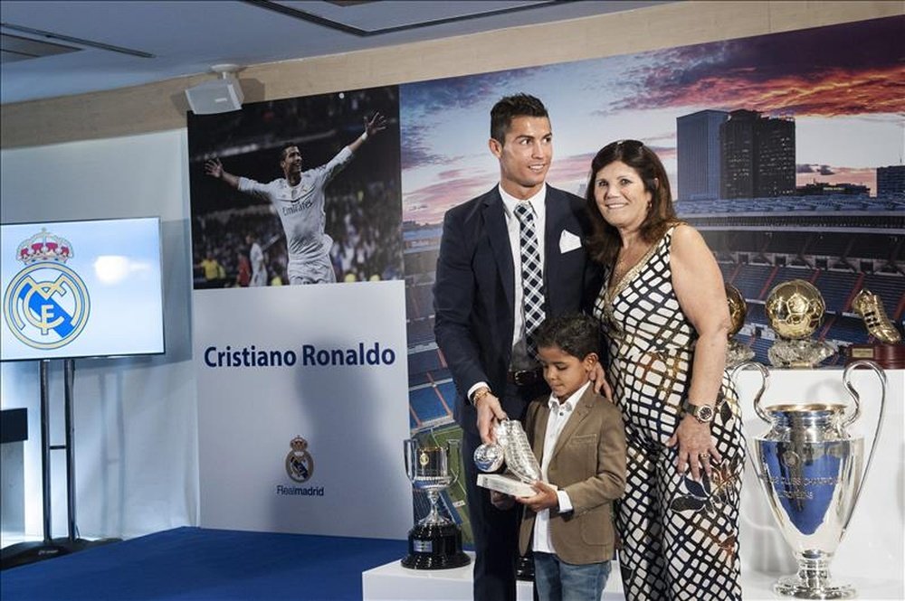 El delantero portugués del Real Madrid, Cristiano Ronaldo, posa con su madre, Dolores Aveiro, y su hijo, Cristiano Júnior, durante el homenaje que el club le ha rendido en el estadio Santiago Bernabéu, con motivo de los 323 goles oficiales que lleva registrados con el conjunto blanco. EFE
