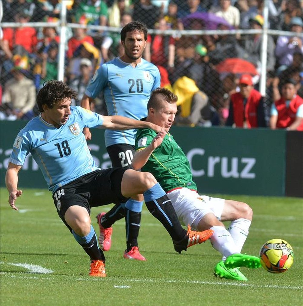 El jugador de Bolivia Alejandro Chumacero (d) disputa el balón con Álvaro González (i) y Mathías Corujo de Uruguay, durante el partido por las eliminatorias sudamericanas del Mundial Rusia 2018, que se disputa en el estadio Hernando Siles de La Paz. EFE