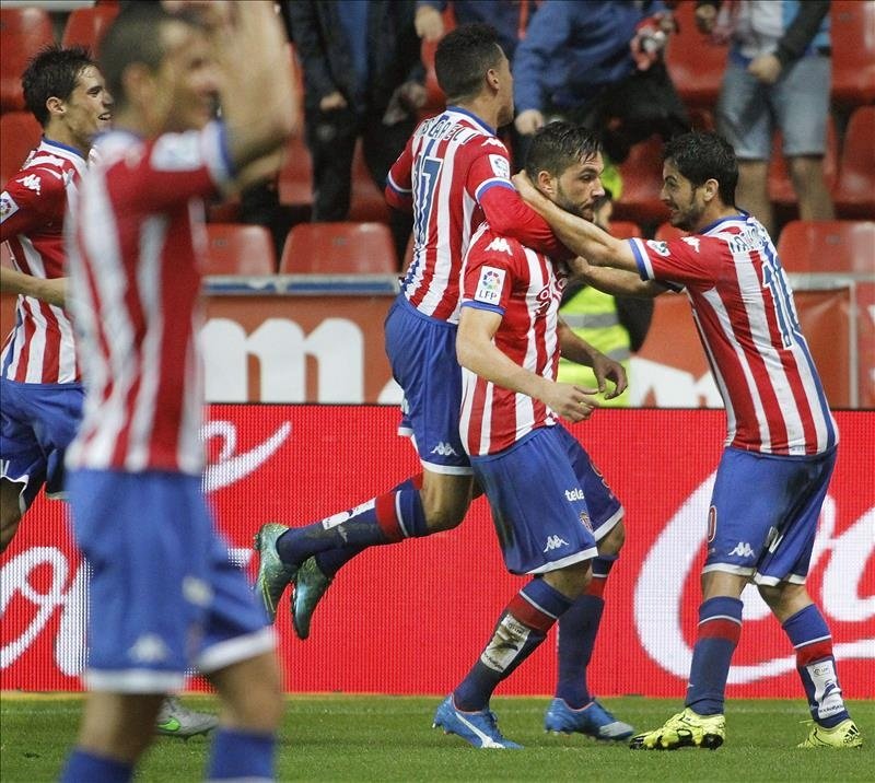 El jugador del Sporting Guerrero (2-d) es felicitado por sus compañeros tras marcar el tercer gol ante el Granada, durante el partido correspondiente a la octava jornada de la Liga en Primera División disputado este lunes en el estadio de El Molinón, en Gijón. EFE