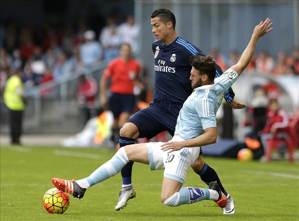 El delantero portugués del Real Madrid Cristiano Ronaldo (i) pelea un balón con el defensa del Celta Sergi Gómez, durante el partido de la novena jornada de liga en Primera División, disputado en el estadio de Balaídos. EFE