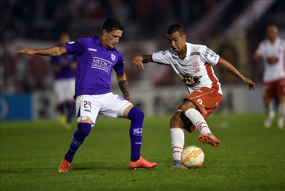 El jugador de Huracán Alejandro Romero Gamarra (d) protege el balón ante la marca de Brian Lozano (i), del Defensor Sporting, el pasado 20 de octubre, durante un partido por los cuartos de final de la Copa Sudamericana, en el estadio de Huracán, en Buenos Aires (Argentina). EFE/Archivo