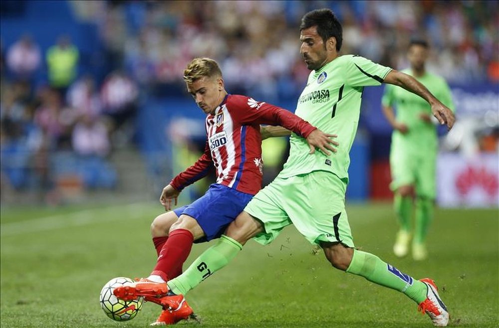 El delantero francés del Atlético de Madrid Antoine Griezmann (i) disputa el balón con Juan Rodríguez, del Getafe CF, durante el partido de la quinta jornada de la Liga de Primera División que se jugó en el estadio Vicente Calderón. EFE/Archivo