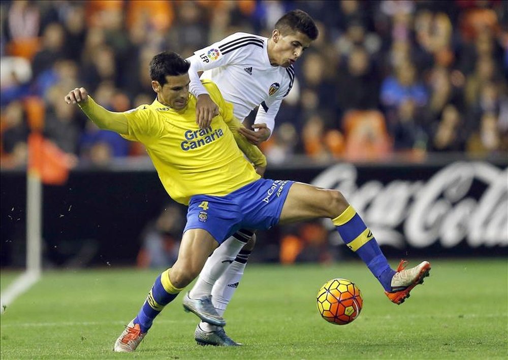El defensa portugués del Valencia Joao Cancelo (d) lucha el balón con Vicente Gómez, de la UD Las Palmas, durante el partido de Liga de Primera División que se disputó este sábado en el estadio de Mestalla, en Valencia. EFE