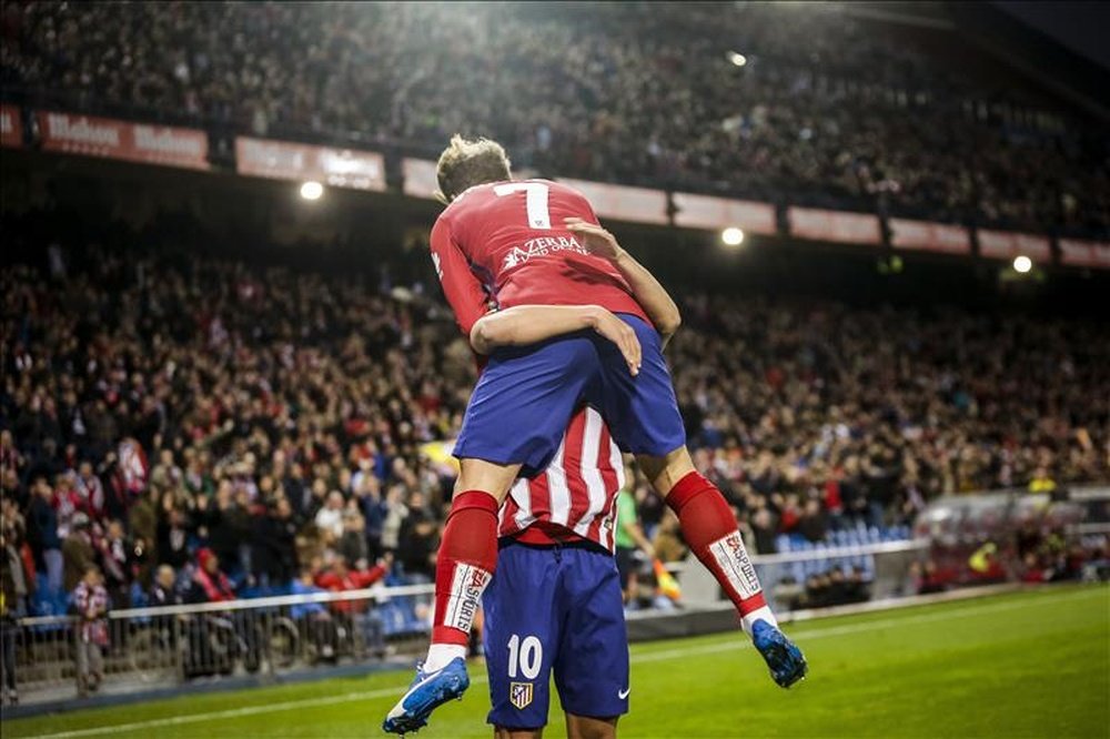 El delantero francés del Atlético de Madrid, Antoine Griezmann, celebra con sus compañero, el centrocampista Óliver Torres, el primer gol que ha marcado frente al Espanyol, durante el partido de la decimotercera jornada de la Liga de Primera División, que se jugó en el Vicente Calderón. EFE