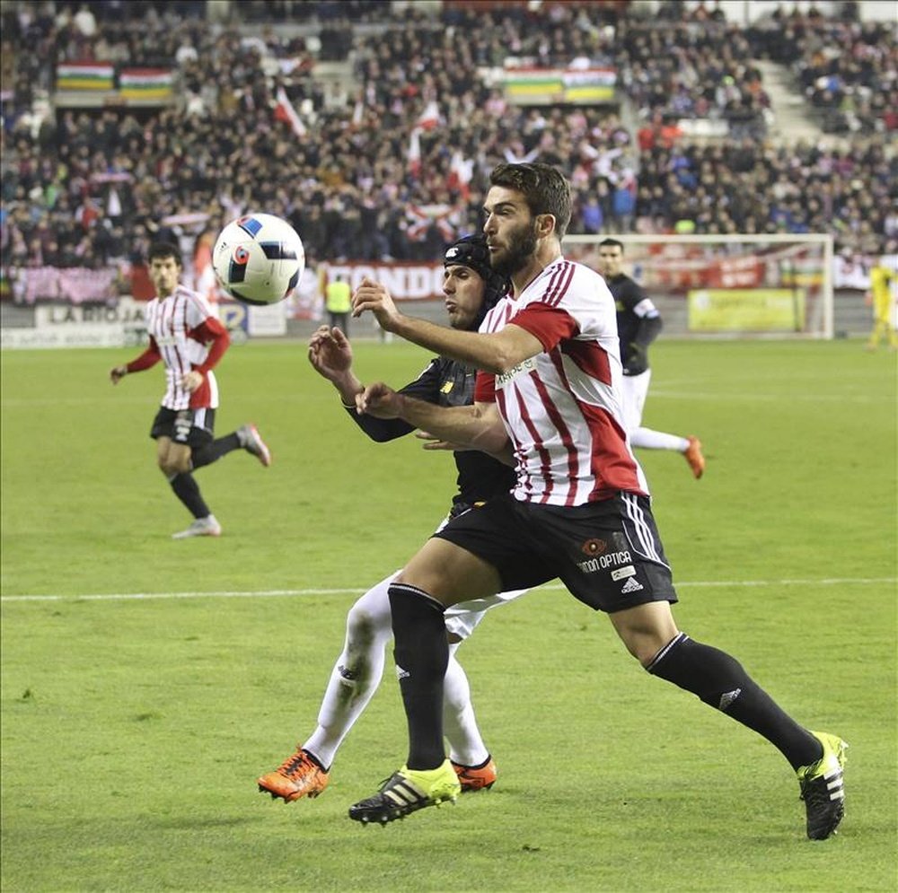 El defensa del Sevilla FC Luismi (i. detrás) lucha el balón con el jugador del Logroñés, durante el partido de ida de dieciseisavos de final de la Copa del Rey que se disputó en el estadio de Las Gaunas, en Logroño. EFE