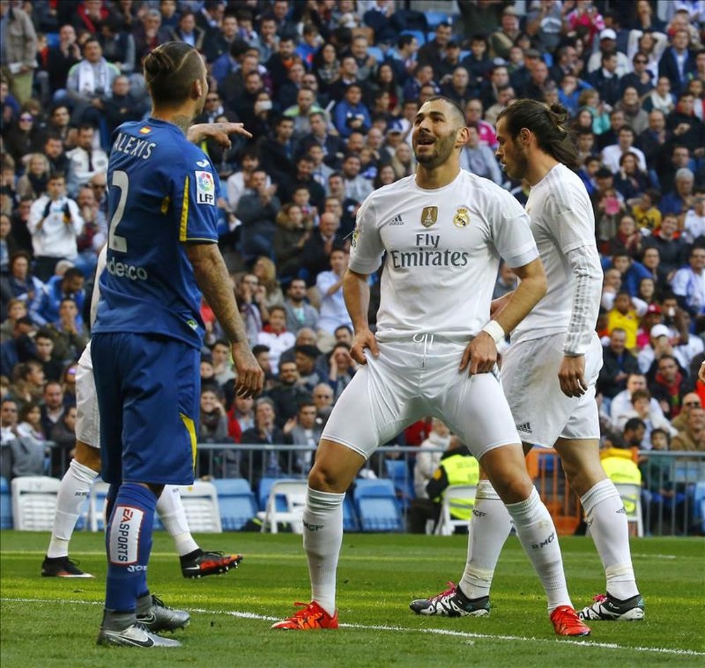 El delantero francés del Real Madrid Karim Benzema (c) junto al defensa del Getafe Alexis Ruano (i) durante el partido de la decimocuarta jornada de liga en Primera División que se disputÓ en el estadio Santiago Bernabéu. EFE