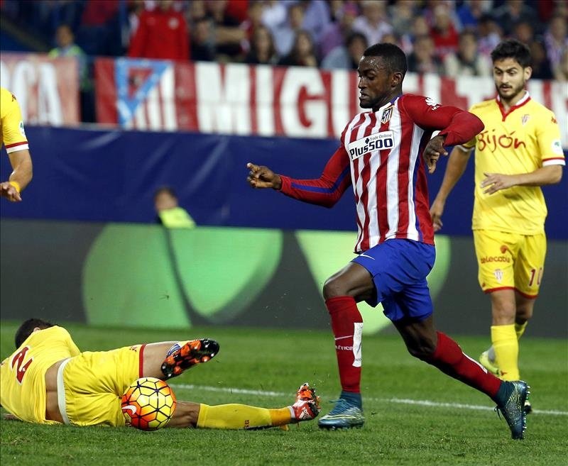 El delantero colombiano del Atlético de Madrid Jackson Martínez (c) pelea un balón ante el defensa del Sporting de Gijón Luis Hernández (i) en partido de la undécima jornada de liga en Primera División que se disputó en el estadio Vicente Calderón. EFE/Archivo 
