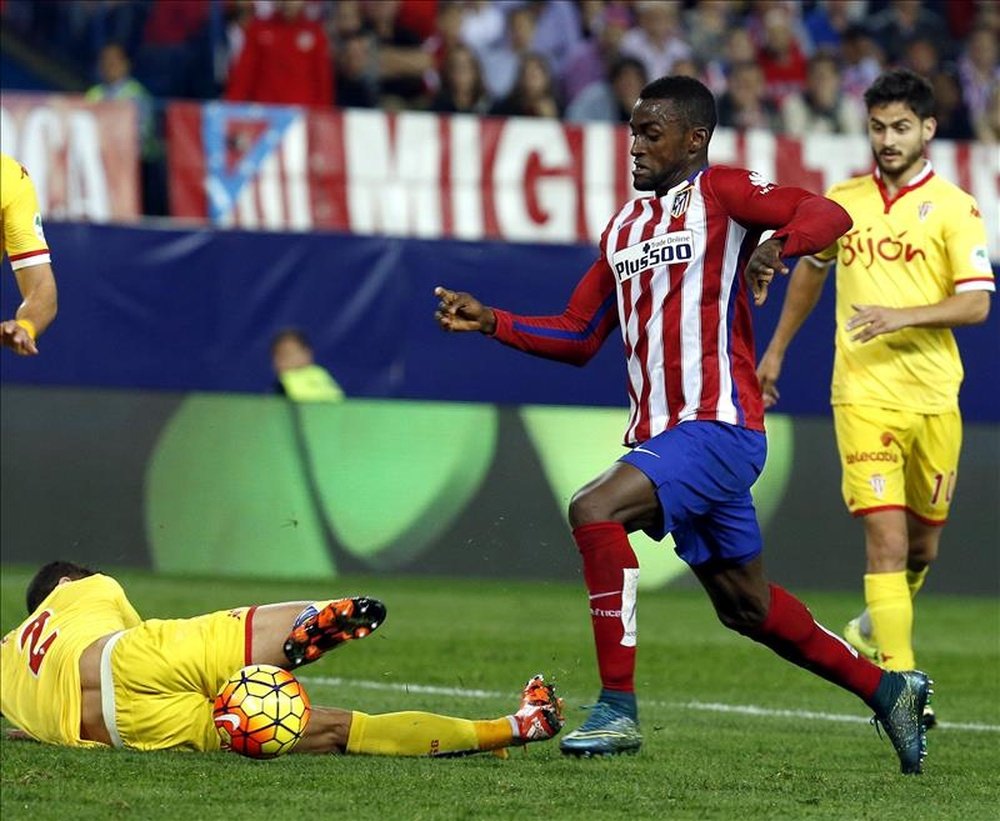 El delantero colombiano del Atlético de Madrid Jackson Martínez (c) pelea un balón ante el defensa del Sporting de Gijón Luis Hernández (i) en partido de la undécima jornada de liga en Primera División que se disputó en el estadio Vicente Calderón. EFE/Archivo