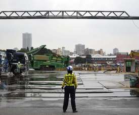 Un agente de seguridad vigila la puerta del recinto donde se prevé la construcción del estadio olímpico de Tokio (Japón). EFE/Archivo