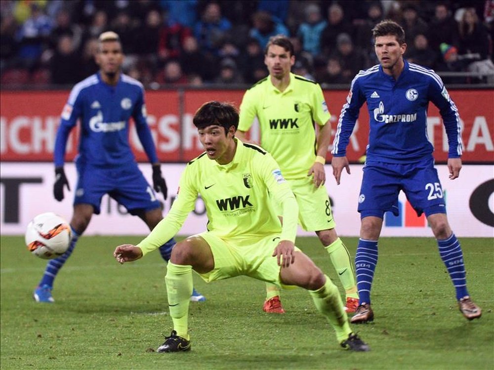 El jugador del Augsburgo Jeong- Ho Hong (c) espera el balón en presencia de los jugadores del Schalke Eric Maxim Choupo-Moting (I) y Klaas-Jan Huntelaar durante el partido de la Bundesliga que han jugado FC Augsburg y FC Schalke 04 en Augsburgo, Alemania. EFE/EPA