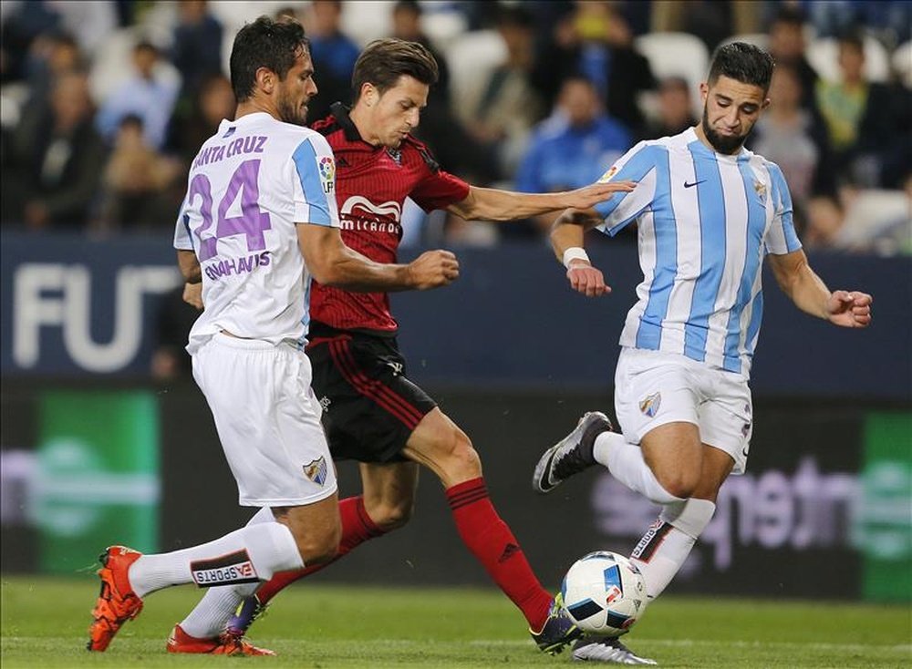 El defensa del Mirandés Ernesto Galán (c) lucha por el balón ante los jugadores del Málaga. EFE