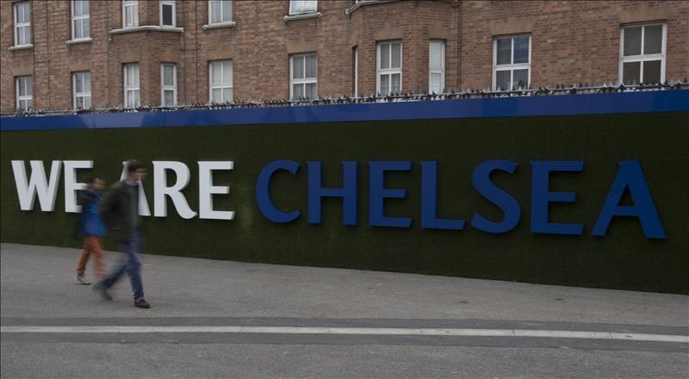 Varios seguidores caminan junto a un cartel publicitario en el Stamford Bridge, Londres, Reino Unido. EFE/Archivo