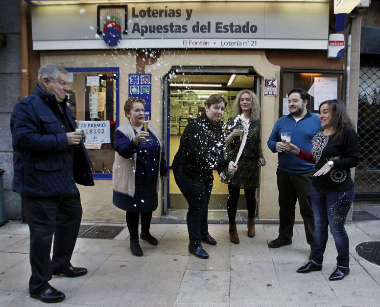 Carmen Llorente (2i), propietaria de la administración número 21 de Oviedo y los empleados de la oficina, donde se ha vendido el 18.102, agraciado con un quinto premio del Sorteo de Navidad, celebran con champán el reparto de la suerte. EFE