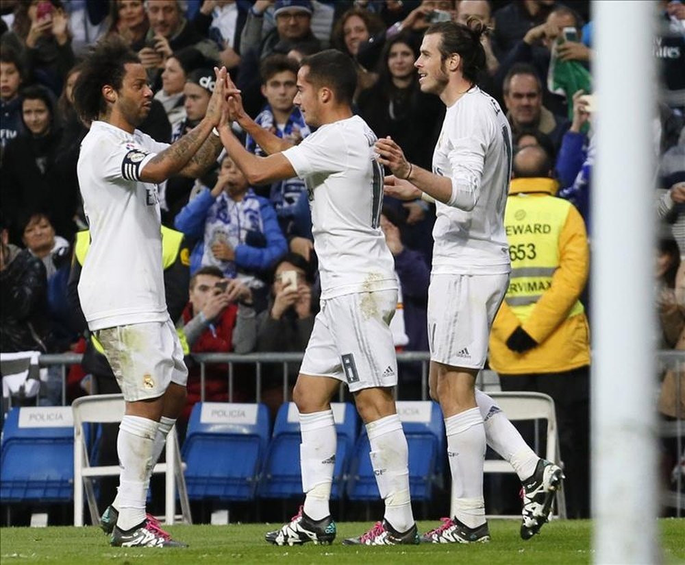 El delantero del Real Madrid Lucas Vázquez celebra con sus compañeros Marcelo Vieira (i) y Gareth Bale (d) el gol marcado ante la Real Sociedad, tercero para el equipo, durante el partido de la decimoséptima jornada de liga de Primera División disputado en el estadio Santiago Bernabéu. EFE