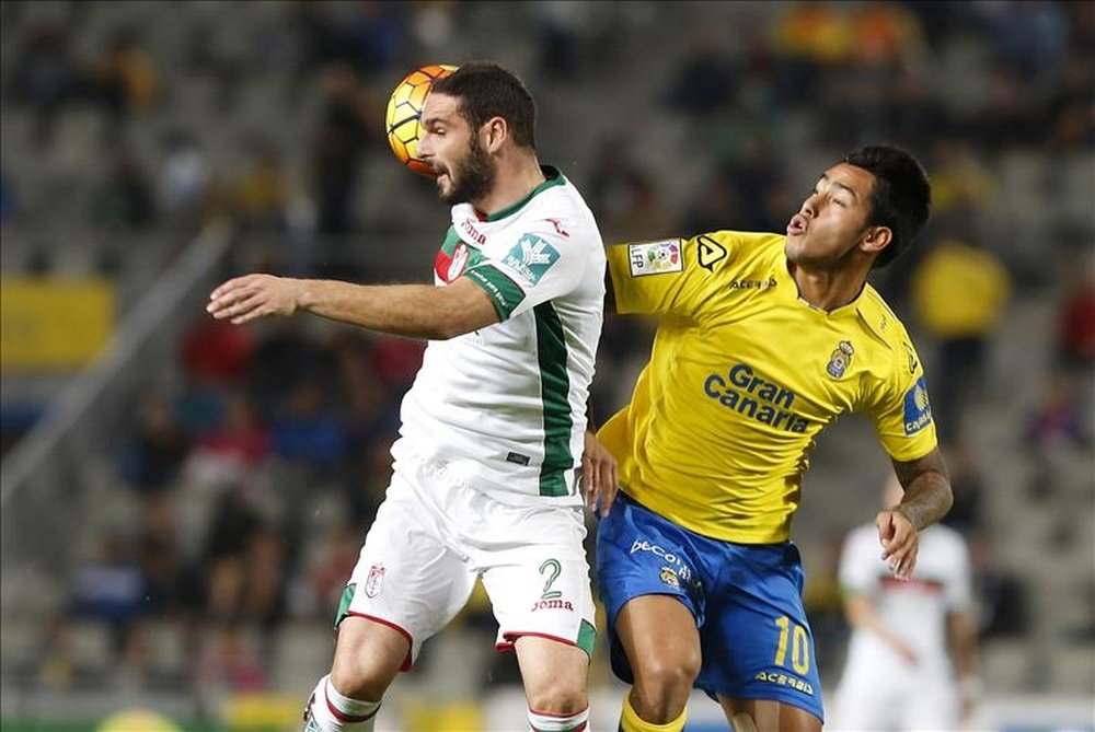 El delantero argentino de la UD Las Palmas Sergio Araujo (d) lucha el balón con Lombán, defensa del Granada, en el partido de la decimoséptima jornada de Liga en Primera División que se disputó en el estadio de Gran Canaria. EFE