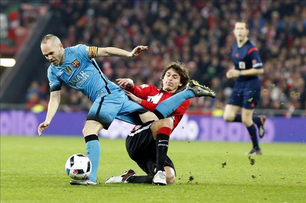 El centrocampista del Athletic de Bilbao Ander Iturraspe (d) disputa un balón con el centrocampista del FC Barcelona Andrés Iniesta (i), durante el partido de ida de cuartos de final de la Copa del Rey. EFE/Archivo