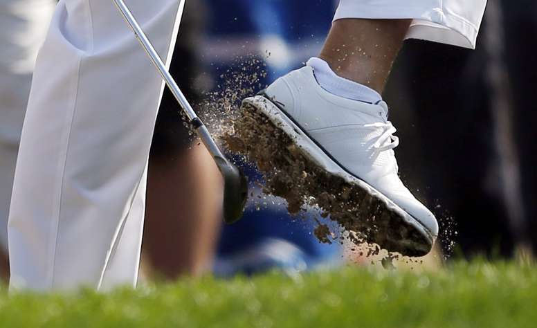Un golfista se sacude arena de la zapatilla  durante la segunda manga del torneo de golf de Abu Dabi (Emiratos Árabes Unidos) hoy. EFE