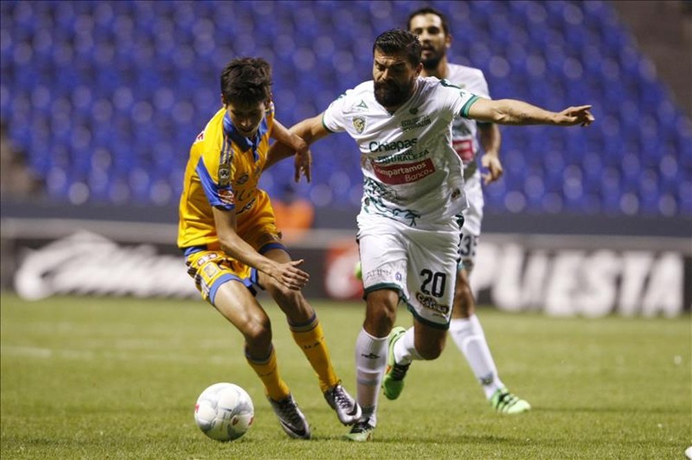 El jugador de Chiapas Félix Araújo (d) disputa el balón con Jürgen Damm (i) de Tigres, en un partido de la jornada 5 del Torneo Clausura del fútbol mexicano, realizado en el estadio Cuauhtémoc, en Puebla (México). EFE