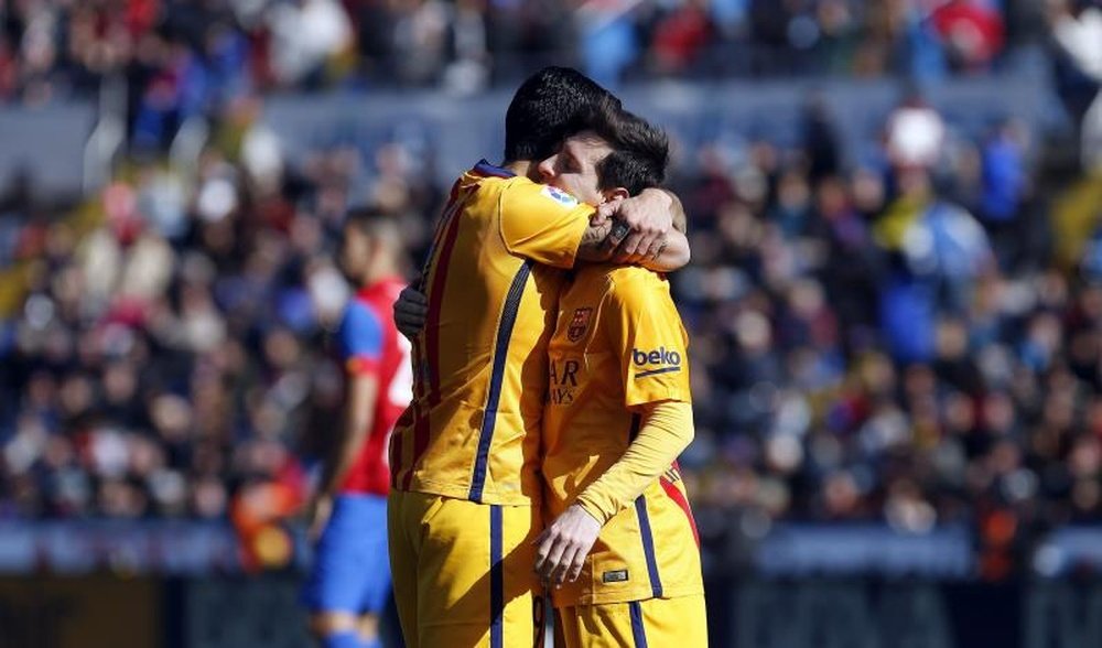El delantero uruguayo del FC Barcelona Luis Suárez celebra con Lionel Messi (i) el gol macado al Levante, segundo para el conjunto azulgrana, durante el partido de la vigesimotercera jornada de la Liga que están disputando esta mañana en el estadio Ciutat de Valencia. EFE