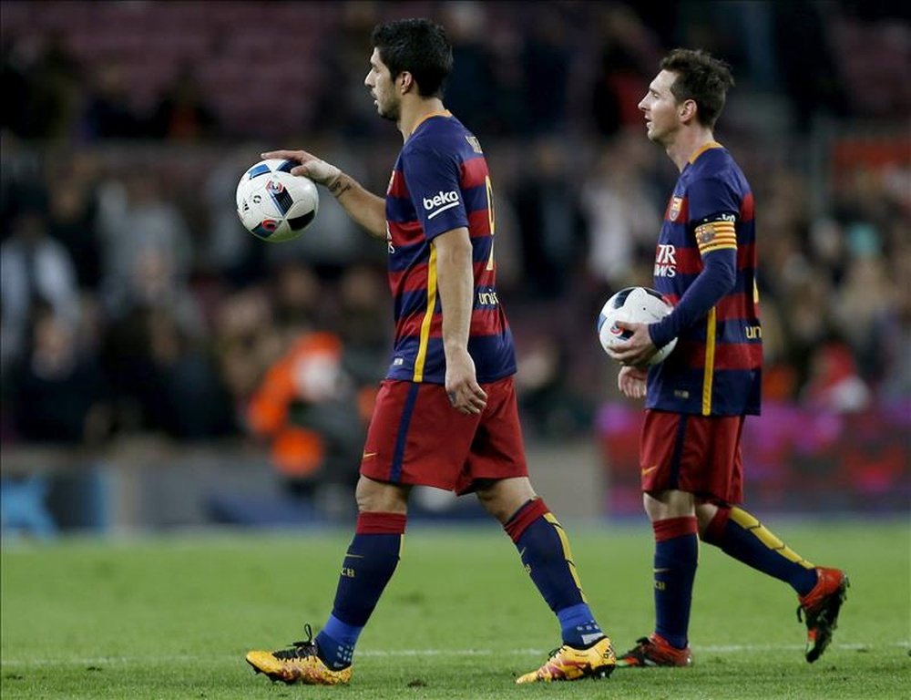 Los jugadores FC Barcelona, el uruguayo Luis Suárez (i) y el argentino Leo Messi, se llevan sendos balones tras conseguir cuatro y tres goles respectivamente, durante el encuentro correspondiente a la ida de las semifinales de la Copa del Rey, que disputaron frente al Valencia en el estadio Camp Nou de Barcelona. EFE/Archivo